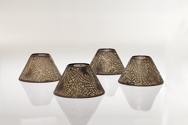 Tiffany Studios Pine Needle Shades : Tiffany Studios Pine Needle Shades A group of four Tiffany Studios bronze candle shades in a pine needle pattern. Each marked Tiffany Studios; ht. 3.5 in., dia 5.25 in.