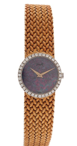 Piaget Wrist Watch in 18 Karat : An 18k yellow gold Piaget wrist watch with an integrated woven mesh band featuring a black opal dial surrounded by 36 VS1-2, G-H color round brilliant diamonds weighing approximately one carat total w