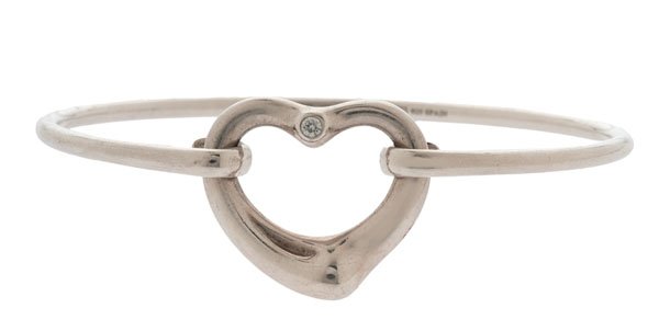 Tiffany & Co. Elsa Peretti Open Heart Diamond Bracelet : A Tiffany & Co. Elsa Peretti signed open heart bangle bracelet in sterling silver containing one VS1, G-H color round full cut diamond weighing approximately .05 carats. Marked 925 Spain. With pouch.