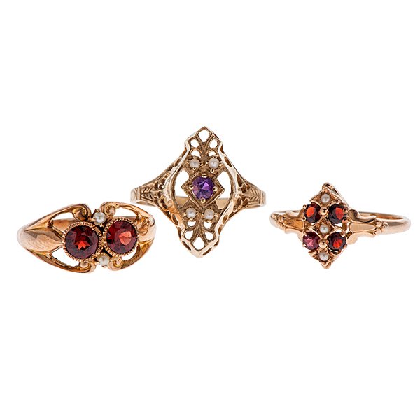 Rings with Garnets, Amethyst, and Pearls in 14 Karat : A trio of 14k yellow gold vintage rings with various stones. The first ring features one round 3mm center amethyst with four accent pearls. The shank contains intricate engraving. Size 8. The second