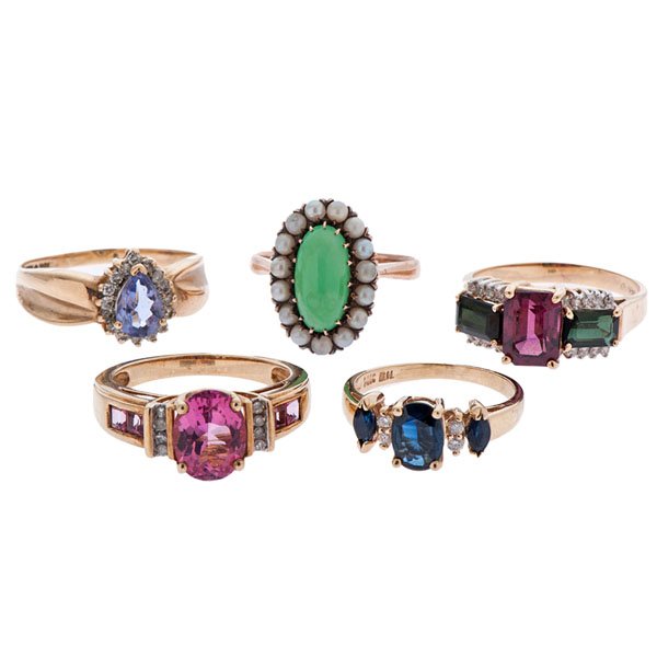 Rings with Gemstones in Karat Gold : A group of five 10k and 14k rings that include various colored gemstones. The first ring is a vintage 10k yellow gold ring featuring a 12mm x 6mm oval cabochon jade surrounded by 15, 2mm round full pe