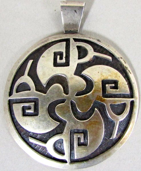 Large Hopi Silver Medallion: The circular silver medallion engraved with traditional Hopi designs, the backgrounds darkened and suspended from a fixed loop. The reverse marked "EY" and "CY". Diameter 2 1/2 inches. Please note: me