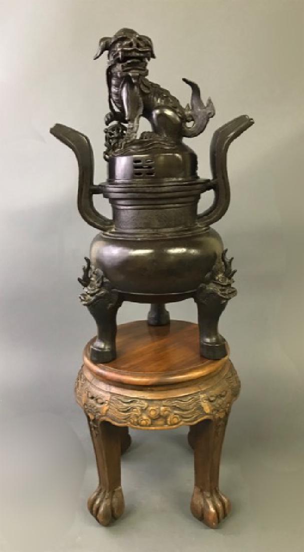 Large Japanese Bronze Foo Dog Incense Burner: Large Japanese bronze Foo dog incense burner, probably late 19th c, 23"h x 14"w, with carved stand, 14"h