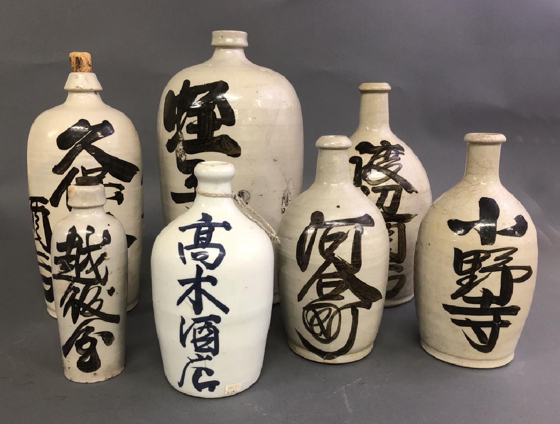 Seven Pottery Sake Bottles: Seven pottery sake bottles, Meiji period, circa 1890, largest 17"h x 8"dia
