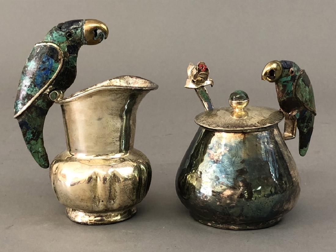 Silverplate Parrot Handle Creamer and Sugar Bowl: Los Castillo Mexican hammered silverplate parrot handle melon form creamer and lidded sugar bowl with spoon, all inlaid with turquoise and lapis lazuli, creamer 4 1/2"h