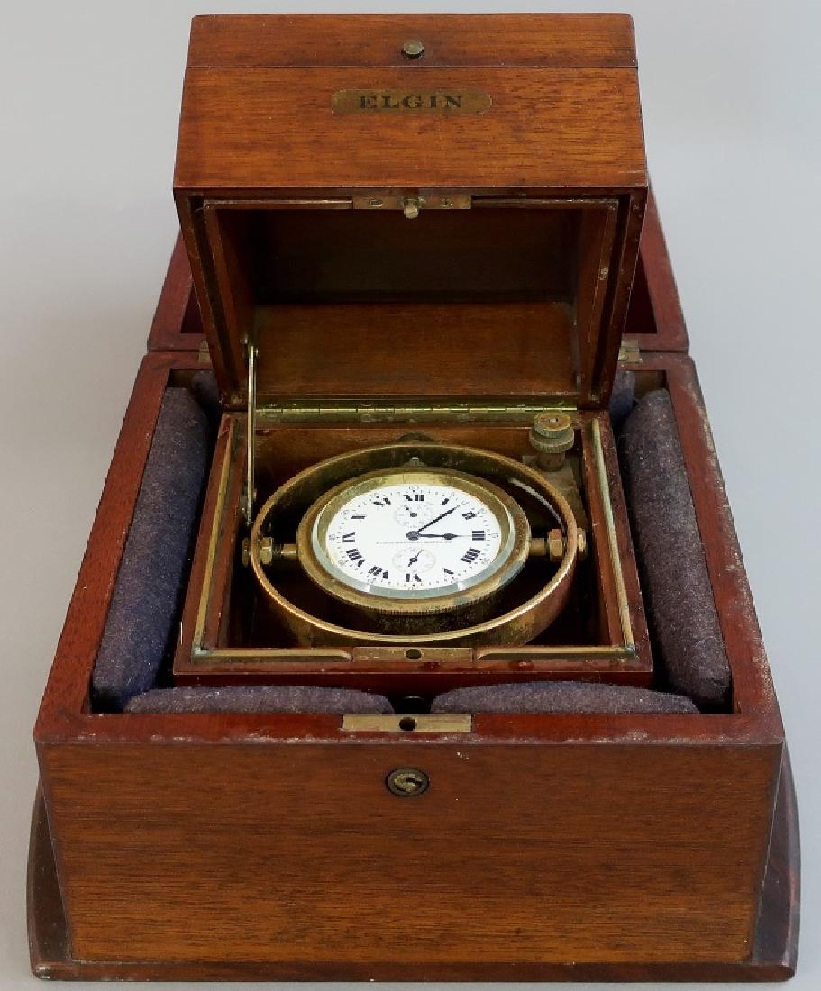 Mahogany Cased Ship's Chronometer by Elgin: Mahogany cased ship's chronometer by Elgin National Watch Co., SN 21869495, crystal 2 14"dia, box 7 1/2"h x 7 1/2"wW.A.I. does not guarantee clocks to be complete or in working condition.