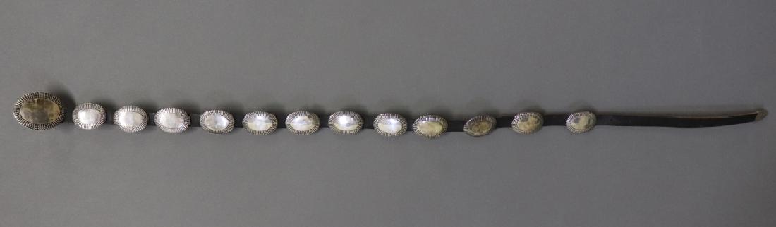 Sterling Silver and Leather Concho Belt: Sterling silver and leather Concho belt having twelve Conchos, not including buckle, 44 1/2" l, buckle 2 3/4"l