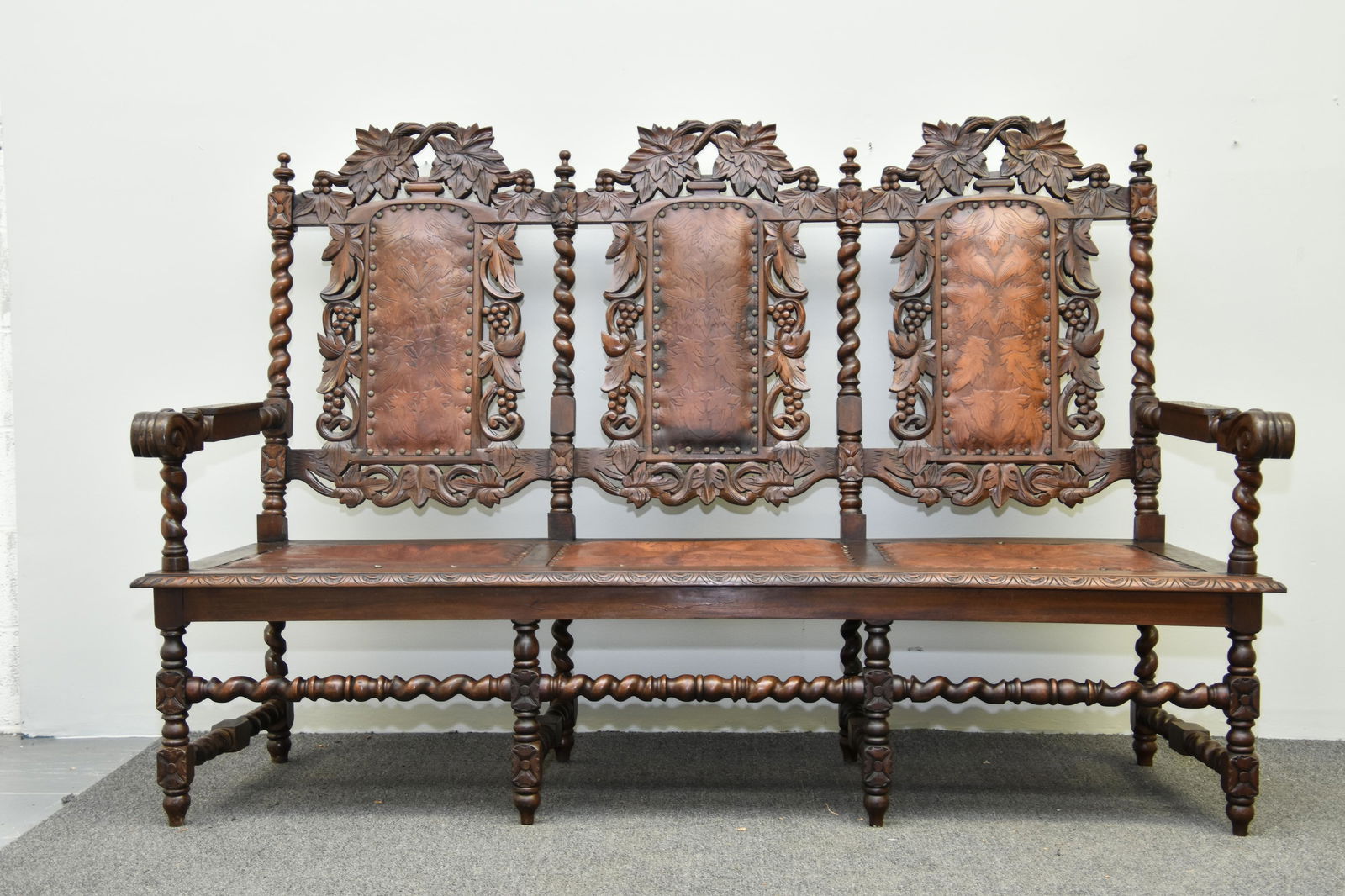 Jacobean Style Walnut Settle: Jacobean style walnut settle, circa 1890 with tooled leather seating and backing 50:h x 73"w x 22"d / seat height 17"