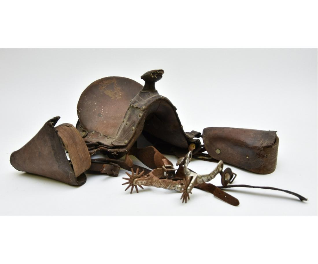 Childs Leather Western Saddle: Childs leather western saddle 10"h x 16"l x 10"w; together with pair of nickel-plated spurs, circa 1900 2.5"h x 6"l all from the White Grass Ranch, Wyoming