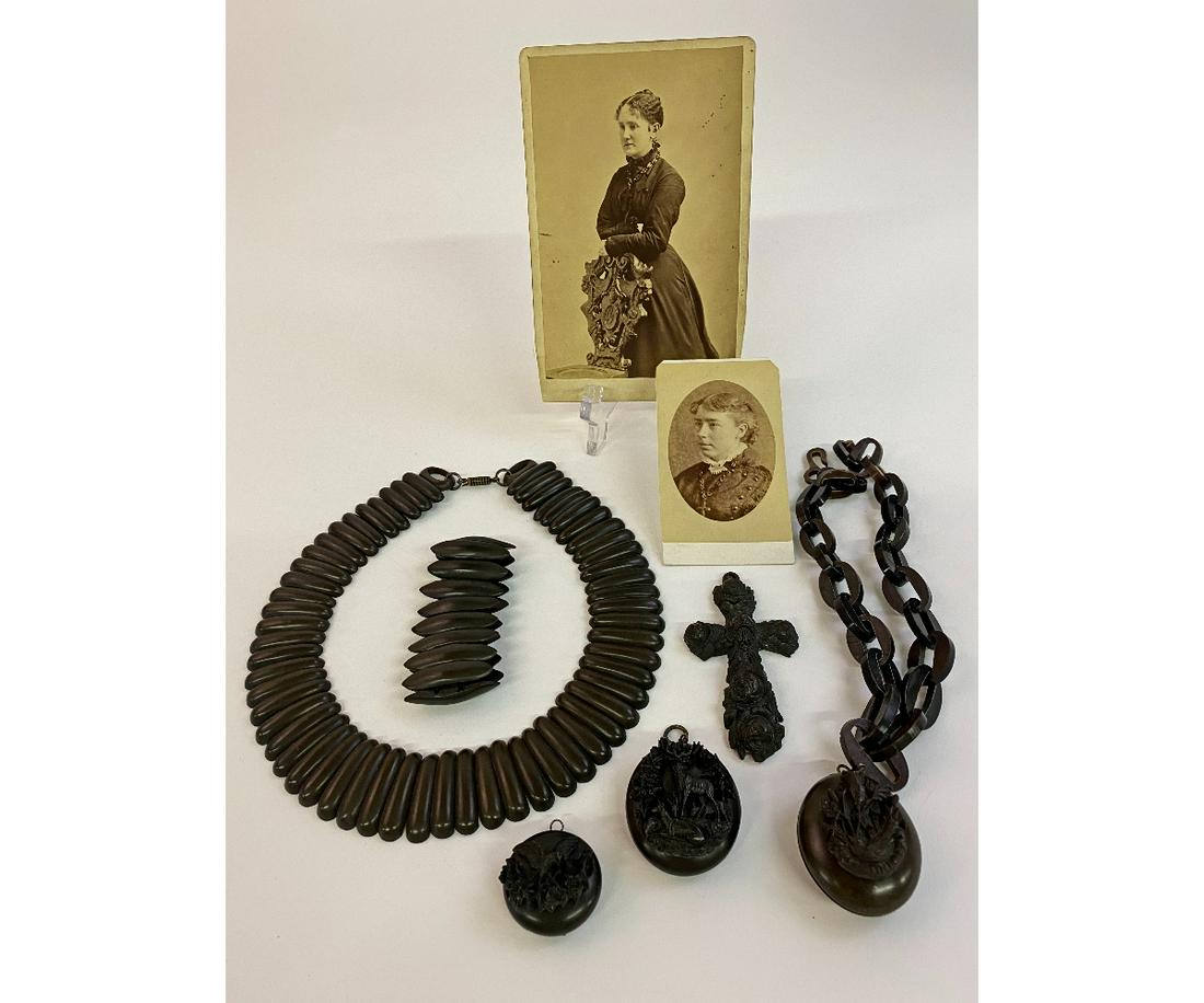 Victorian Gutta Percha Mourning Jewelry: Victorian gutta percha mourning jewelry to include a necklace (8"dia) with a matching bracelet, three carved mourning lockets one with a chain design necklace 17"l, a cross and two period photographs