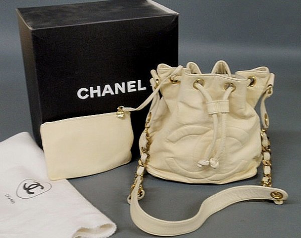 Chanel vanilla kid leather drawstring purse with q: Chanel vanilla kid leather drawstring purse with quilted front logo, interior flat purse on strap, interwoven gold tone and leather strap, dust cover, box, label and card of authenticity. 9"h.x8"w.x5.
