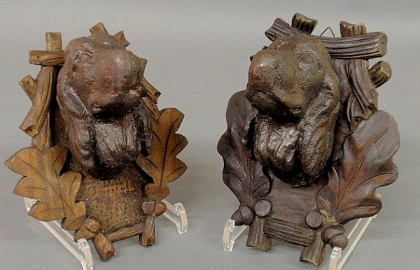 Two similar Black Forest carved dog heads, late 19: Two similar Black Forest carved dog heads, late 19th c., mounted on oak leaf and acorn shield plaques. 8.5"h.x7"w.x5.5"d.
