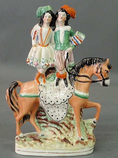Staffordshire figural group of a boy and girl stan: Staffordshire figural group of a boy and girl standing on the back of a horse. 10"h.x7.25"w.