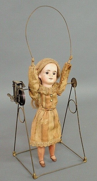 French bisque head automation doll jumping rope wi: French bisque head automation doll jumping rope with metal arms and composition legs, probably late 19th c., the mechanism marked "Germany". Doll 11.5"h., OA 16.5"h.x8.5"w.