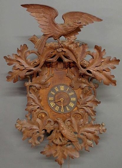 Black Forest cuckoo clock, c.1900, with carved bir: Black Forest cuckoo clock, c.1900, with carved birds and oak leaves, double weight driven and with an extra weight Note: there are 3 weights- it is a two-weight driven clock. 35"h.x23"w.x10"d.