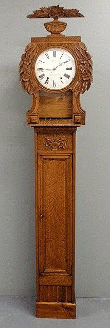 French oak tall case clock, 19th c., with floral c: - French oak tall case clock, 19th c., with floral carved hood and porcelain dial signed “F. Carel, a Longueville”. 84”h.