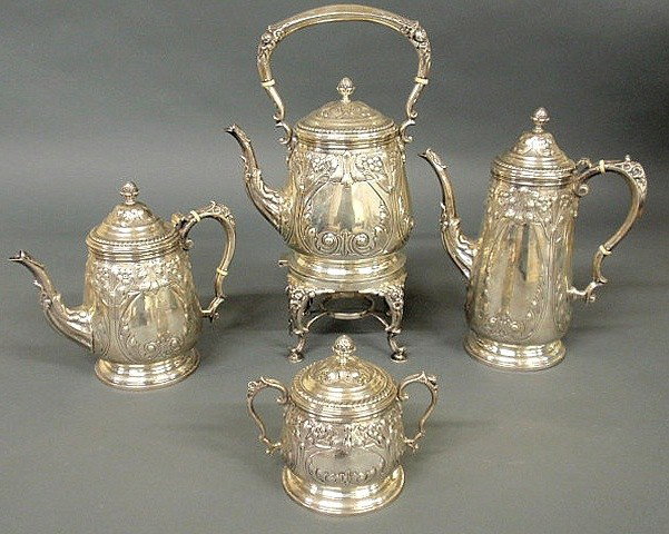 Sterling silver four-piece tea service with an orn