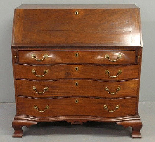 New England Chippendale mahogany oxbow slant-lid: New England Chippendale mahogany oxbow slant-lid desk, c.1780, with a pigeonholed and document drawered interior, carved skirt and bold ogee bracket feet. 43.5"h.x42"w.x22"d.