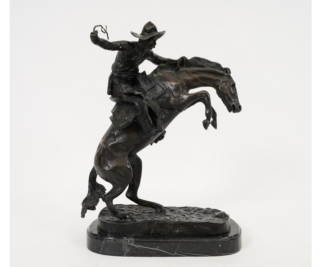 REMINGTON BRONCO BUSTER BRONZE: Frederic Remington (after) bronze "Bronco Buster" mounted on a black marble base. 23"h x 18"w x 11"d