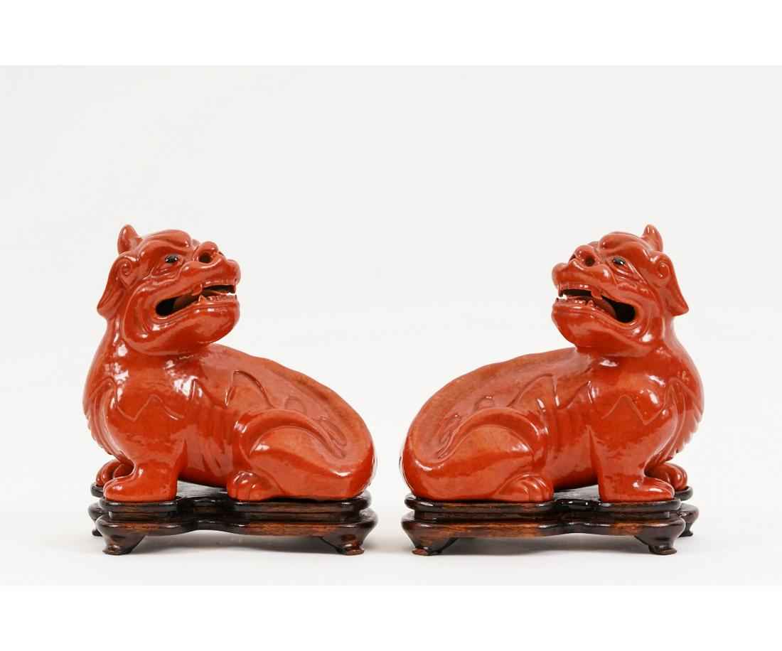 PAIR OF CHINESE PORCELAIN FOO DOGS: Pair of Chinese red porcelain seated foo dogs on wood bases. 8.25"h x 7.5"l x5"w Providence: Bonham's Auction house