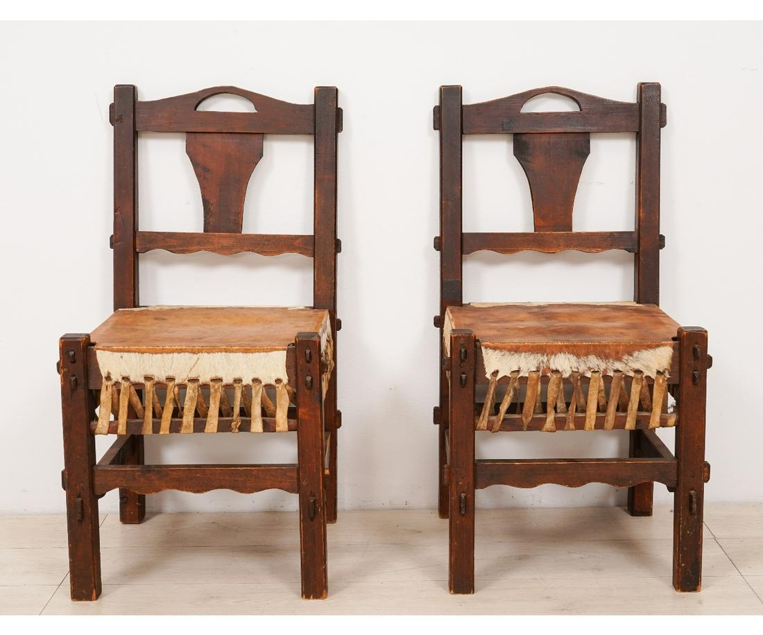 PAIR OF ARTS & CRAFTS CHAIRS: Pair of Arts & Crafts oak side chairs with stretched cow hide seats, circa 1910. 34"h x 17"w x 17"d