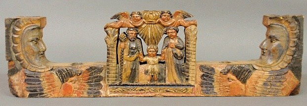 Unusual carved and paint decorated candleholder, : Unusual carved and paint decorated candleholder, 19th c., with two angels above a man, child and woman and glancing angels and faces, possibly South American. 7"h.x25"w.x2"d.