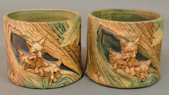 Pair of Weller pottery jardinières with relief sc: Pair of Weller pottery jardinières with relief scenes of foxes hiding in tree trunks, one marked "K" (Knauss). 6"h.x7"dia.