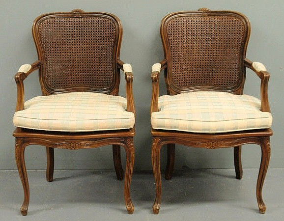 Pair of French fruitwood fauteuils, 20th c., with: Pair of French fruitwood fauteuils, 20th c., with caned backs and seats. 36.5"h.x22"w.x20.5"d., seats 17"h. & w/cushions 20"h.