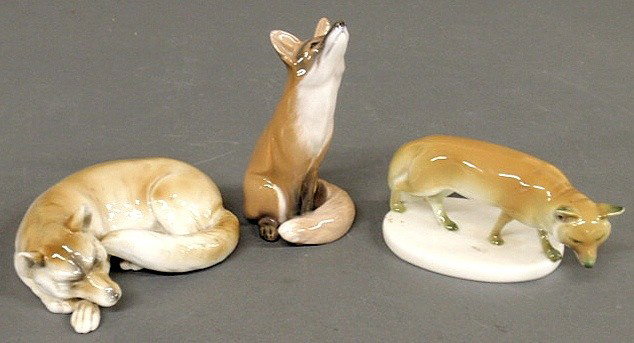 KPM porcelain figure of a standing fox on an oval: KPM porcelain figure of a standing fox on an oval base 3"x6", Royal Copenhagen porcelain figure of a seated fox 6"h. and a sleeping fox 6"l.
