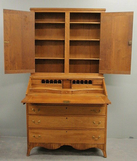 Hepplewhite cherry two-part secretary bookcase, c: Hepplewhite cherry two-part secretary bookcase, c.1800, with two blind doors opening to a shelved interior above a lower section with a lift lid opening to an unusual pigeonholed and serpentine docume