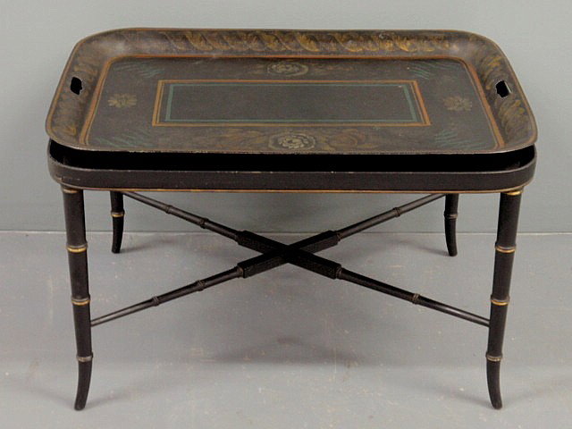 Black Regency Tole decorated tray table with a ba: Black Regency Tole decorated tray table with a bamboo turned base of a later date. 19”h.x30”w.x23”d.