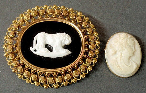 Two 14k yg cameo brooches- one with an elaboratel: Two 14k yg cameo brooches- one with an elaborately framed carved white lion applied to a black onyx reserve and the other a shell cameo of a woman, 15.4dwt.