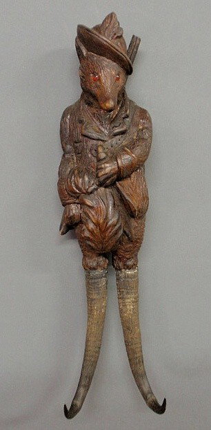 Black Forest coat hook, late 19th c., carved in t: Black Forest coat hook, late 19th c., carved in the form of a fox with red glass eyes. 14”h.