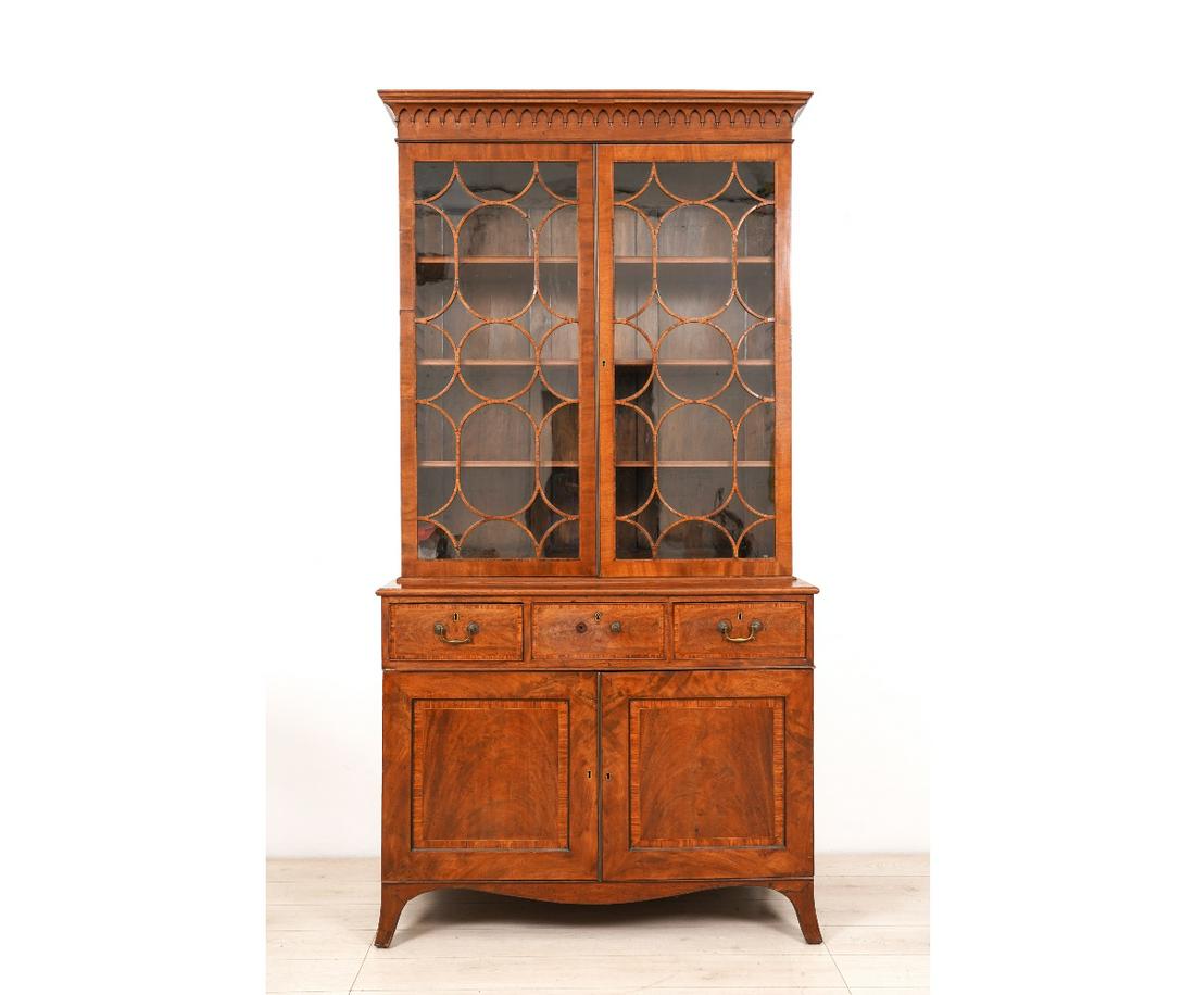 GEORGE III SERVANTS SECRETARY: George III mahogany servants secretary, circa 1810, with shelved upper section with glass doors above a center drawer with writing surface above two doors over two drawers, all ending in flaring Frenc