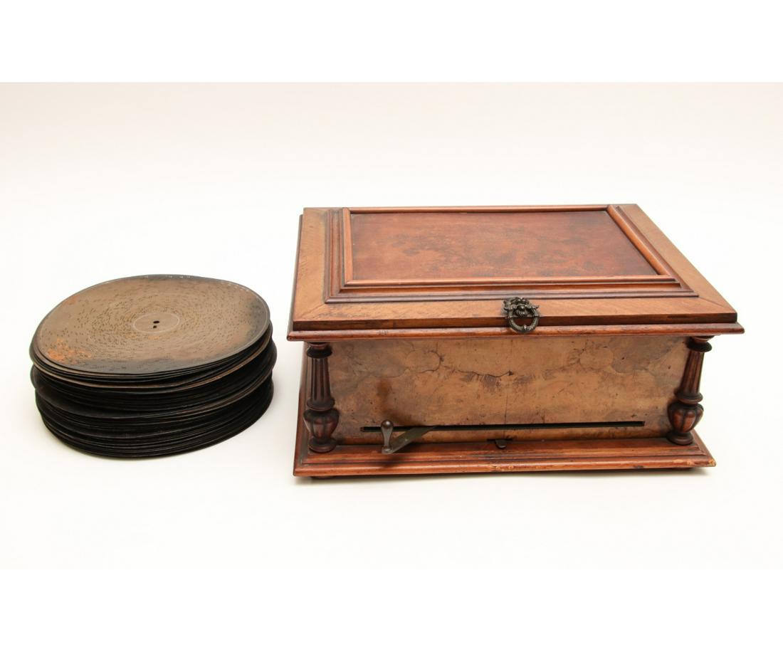 SYMPHONION DOUBLE-COMB MUSIC BOX: Symphonion double-comb disc music box in an ornate walnut veneered case with front ratchet wind motor, circa 1890, not marked, with 48 12" discs, serial # 90809, in working condition. 9.5"h x 19.5"w x