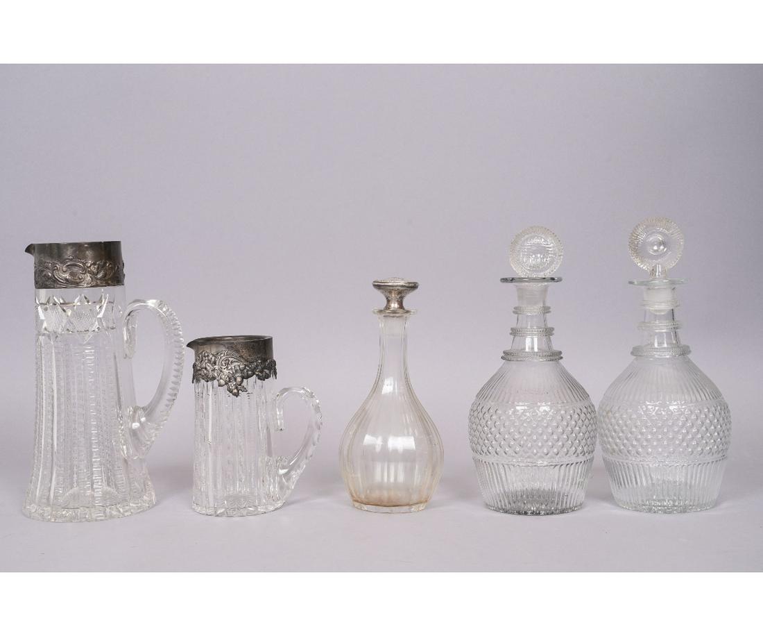 SILVER RIMMED CUT GLASS PITCHERS etc.: Two cut glass sterling silver rimmed pitchers, late 19th c., tallest: 10"h x 4.75"dia (very small flea bites); together with a pair of blown glass decanters and another decanter (no lid).