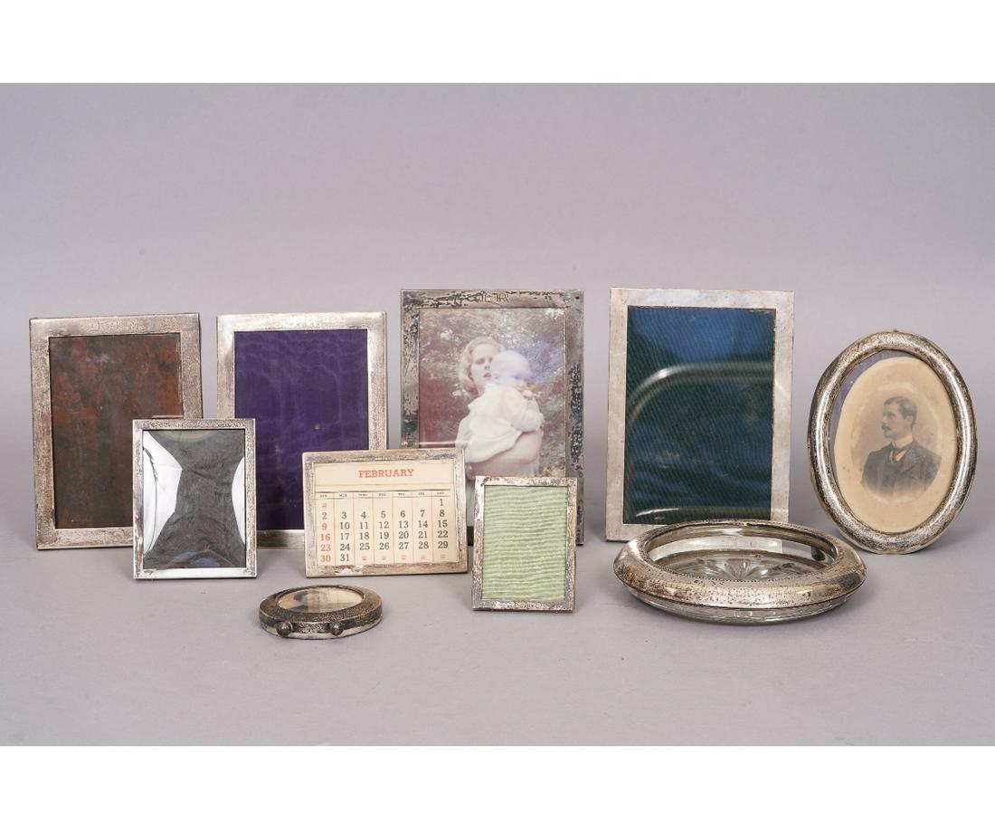 STERLING SILVER FRAMES: Seven sterling silver picture frames the largest 7"h x 5"w; together with a silver and glass ashtray "Rear Commodore's Prize..." 7"dia.