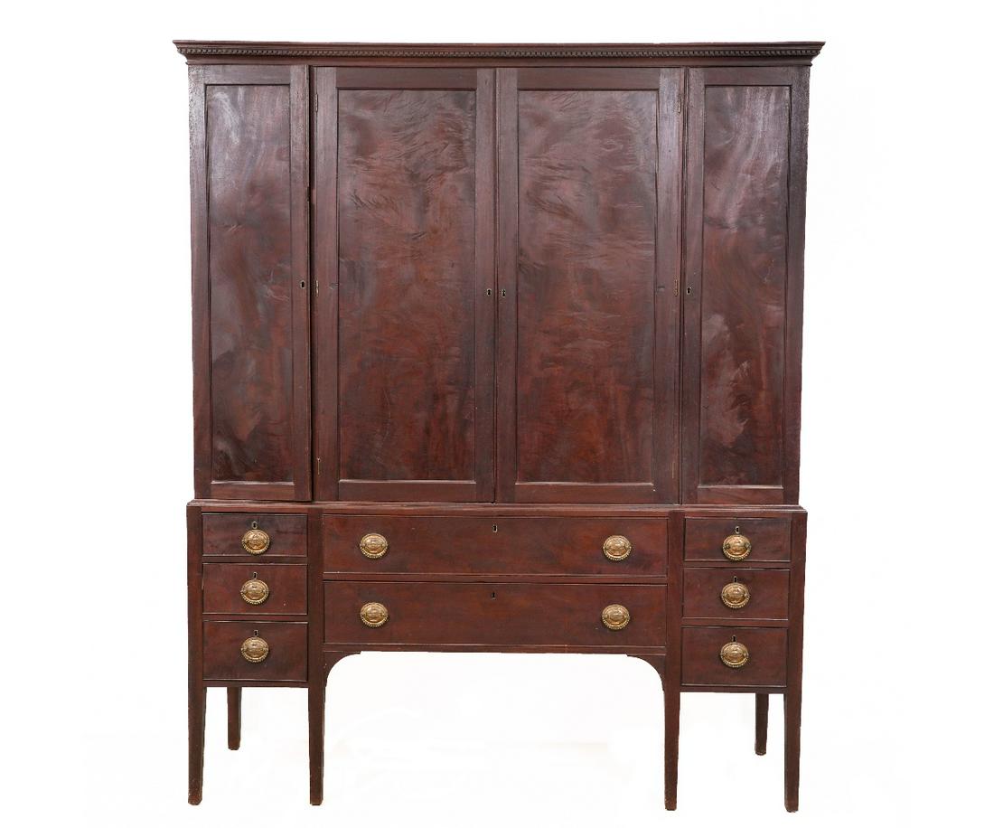 AMERICAN HEPPLEWHITE CUPBOARD: American Hepplewhite mahogany two-piece cupboard, circa 1790, having a dentil molded cornice, above four blind doors, all above a lower section with 8 drawers and square tapered legs. 86"h x 70"w x 19