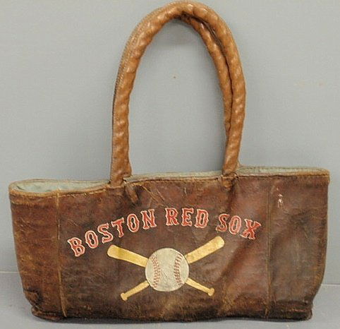 Leather Boston Red Sox satchel, c.1900, used to c: Leather Boston Red Sox satchel, c.1900, used to carry gloves, baseballs, etc., with oversized long handles. 32”h.x32”w.