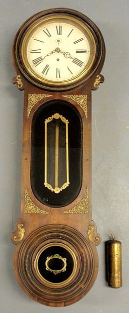 Walnut Parliament clock, late 19th c., with brass: Walnut Parliament clock, late 19th c., with brass ormolu mounts and reverse painted black and gilt glass. 51”h.x16”w.x8”d.