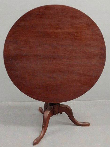 Southern mahogany tea table, early 19th c., with: Southern mahogany tea table, early 19th c., with a circular top, long leaf pine support, turned shaft and snake feet. 27”h.x35”dia.