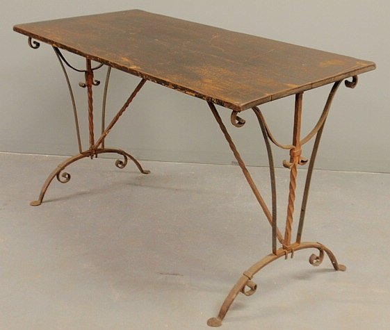 Wrought iron table base in the manner of Samuel Y: Wrought iron table base in the manner of Samuel Yellin, with a wood top. 30”h.x50”w.x24”d.