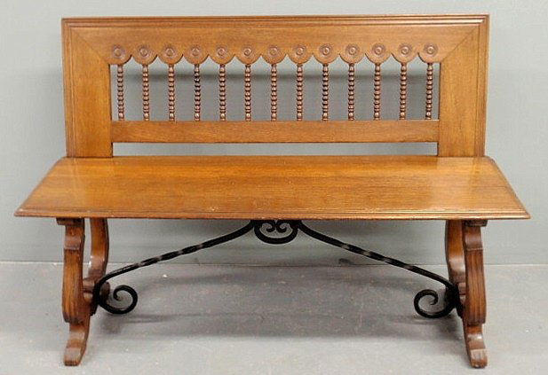 Italian walnut bench with spool carved back and wr: Italian walnut bench with spool carved back and wrought iron stretcher base. 32.5”h.x48”l.x18”d., seat 18”h.