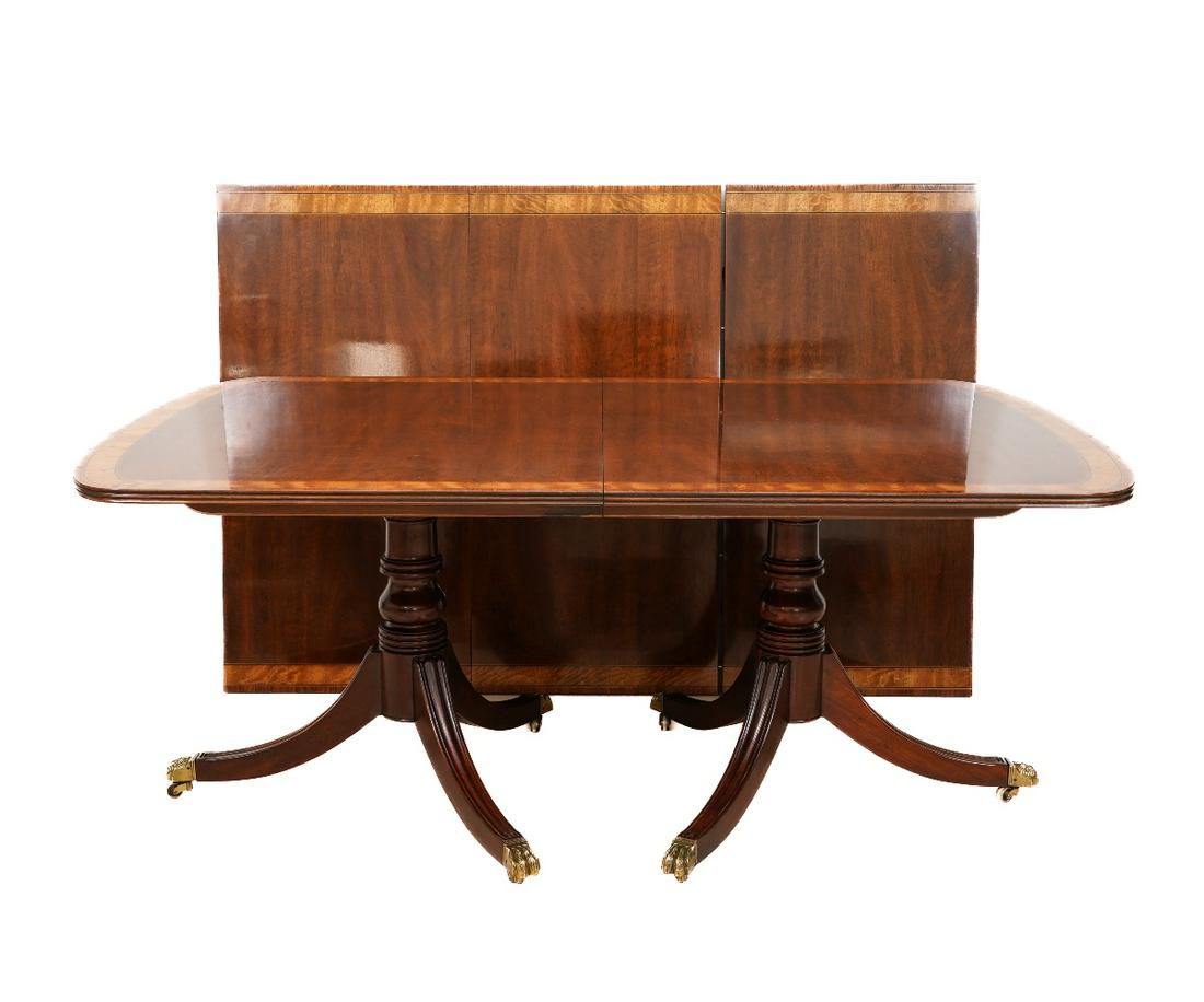 HENREDON BANQUET TABLE: Henredon mahogany banquet table with three leaves, inlaid border, double pedestal base, reeded down swept legs and brass cuffs and casters. 29"h x 45"w x 134.25"l (fully extended)