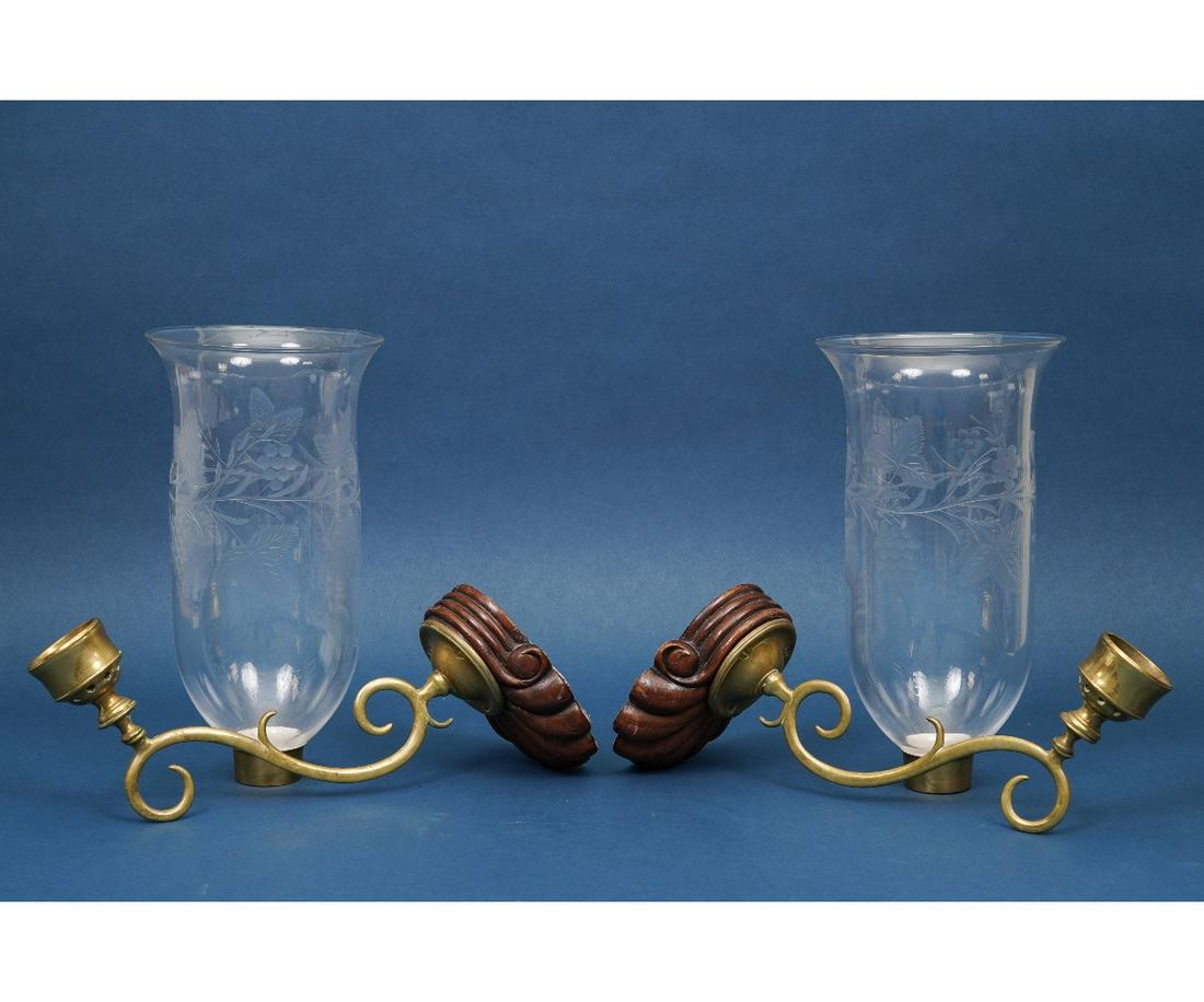HURRICANE WALL SCONCES: Pair of brass and glass hurricane wall sconces with carved mahogany shell backs, the shades with etched grape vine motifs. 22"h x 12"d x 5"d approximately
