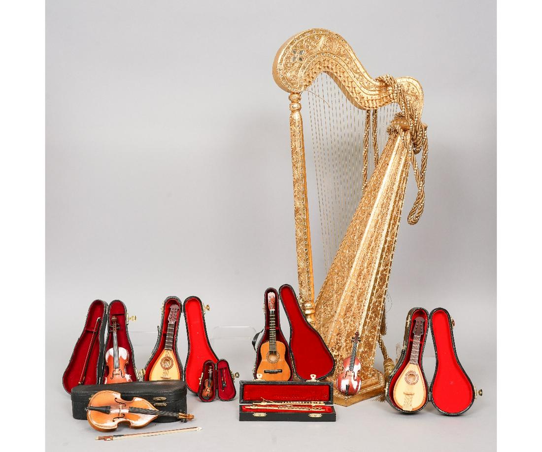 MINATURE STRINGED INSTRUMENTS: Grouping of miniature toy stringed instruments to include a large gold colored harp, 29.5"h x 13.5"w x 7.75"d; cello with horsehair bow and rosin, 8.5"l; guitar, 7.75"l; two mandolins, 7"l; 2 flutes, 