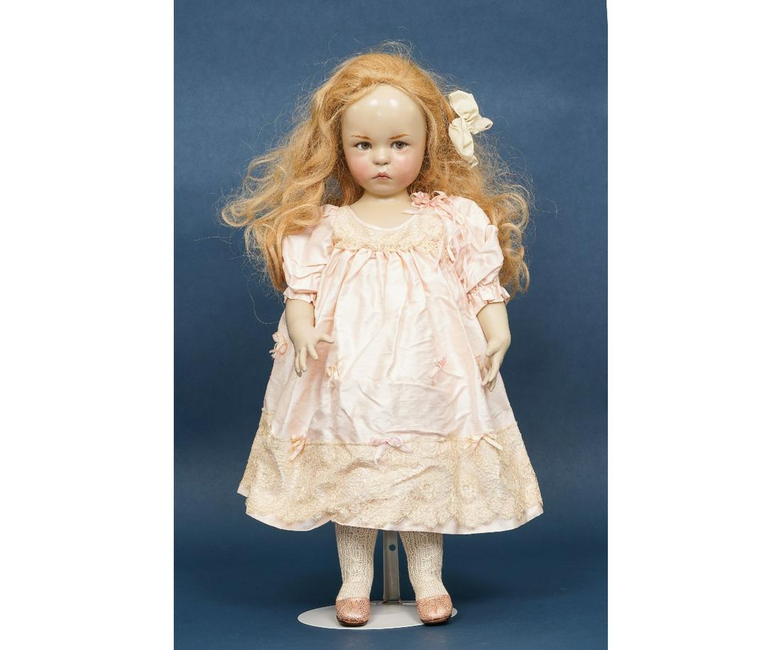 BRIGITTE DEVAL BABY 1: Wax over porcelain doll marked "Brigitte Deval Baby I, #64/100 dated 1992, with hazel eyes, blonde hair, cloth torso, porcelain arms, legs and head/shoulders, dressed in peach silk, trimmed with lace 