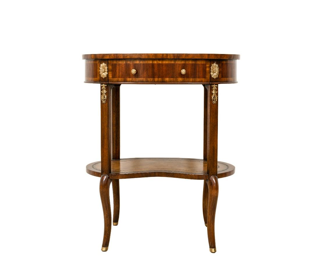 MAITLAND SMITH OVAL TABLE: Maitland-Smith mahogany oval leather top table with brass mounts and lower leather top shelf. 30.25"h x 25.5"w x 17.75"d