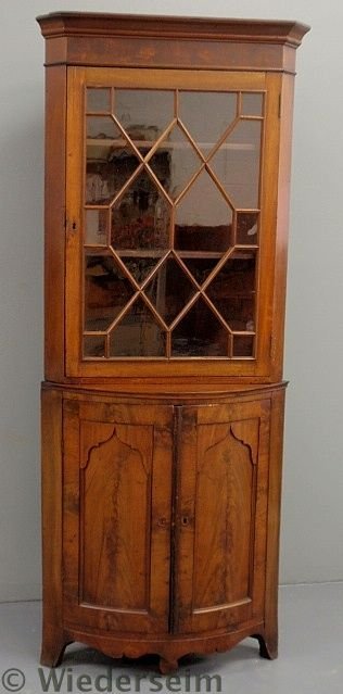 English mahogany corner cupboard with a molded co: English mahogany corner cupboard with a molded cornice and mullioned glass door above two turkey-breasted paneled doors and flaring French feet. 71”h.x28”w.x19”d.