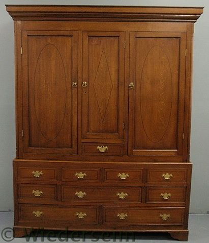 English oak two-piece linen press, 19th c., with: English oak two-piece linen press, 19th c., with ebony inlays, molded cornice above three doors and a single center drawer above a lower section with four faux drawers over five drawers al resting on
